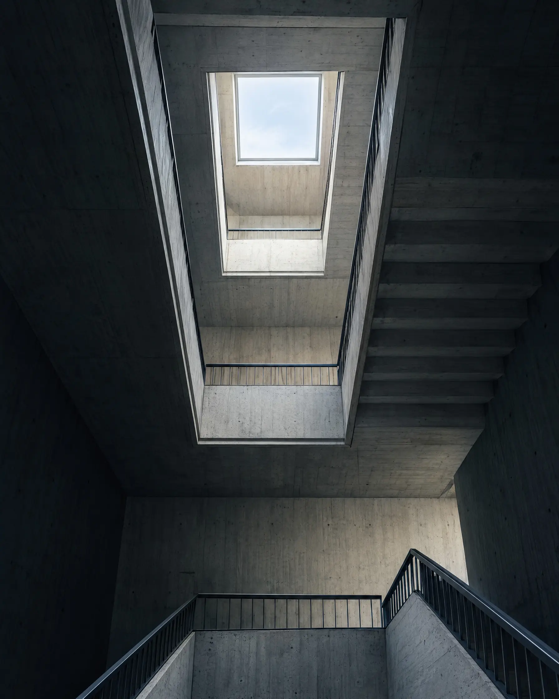 Treppenhaus aus Sichtbeton, von unten zum Oberlicht gesehen